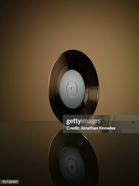 vinyl record on reflective surface - schallplatte stock-fotos und bilder