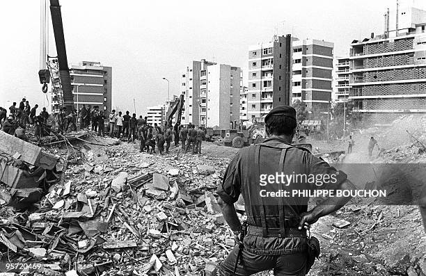 French soldier watches 25 October 1983 in Beirut the rubble of the -Drakkar- building which was destroyed by a suicide truck bomber overnight, 23...