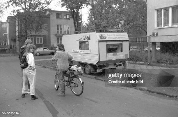 Zwei junge Leute aus der DDR sprechen mit einer einheimischen Fahrradfahrerin in der Nähe der Botschaft der Bundesrepublik Deutschland in Warschau,...