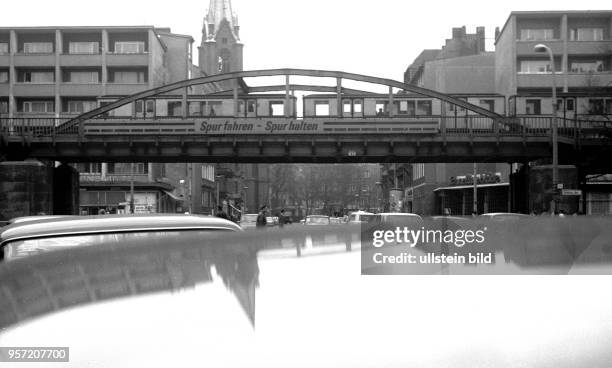 Eine U-Bahn spiegelt sich in der Schönhauser Allee im Berliner Stadtbezirk Prenzlauer Berg in dem Dach eines Autos wider, aufgenommen 1980. Die...