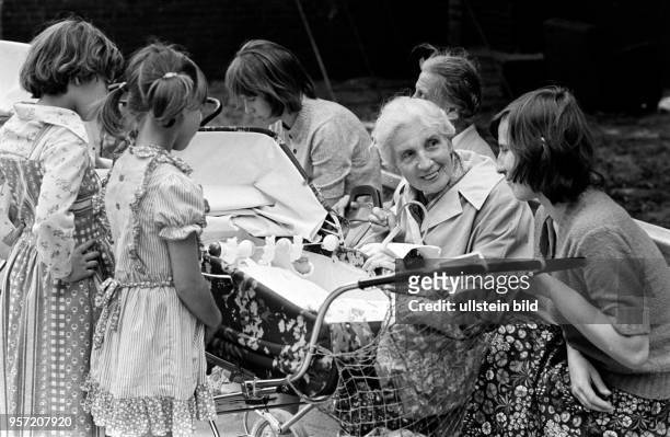 Treffen der Generationen: Eine Mutter sitzt auf einer Parkbank und unterhält sich mit einer älteren Frau, aufgenommen im August 1977 im Berliner...
