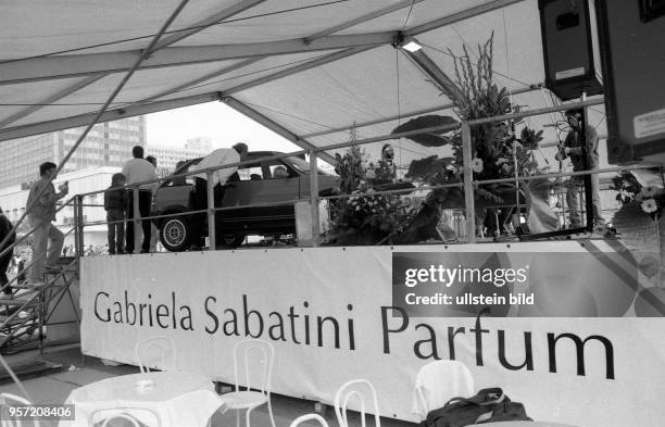 Bei einem PR-Termin mit Tennisstar Gabriela Sabatini auf dem Ostberliner Alexanderplatz wird auch für die Parfümmakrke der Profisportlerin geworben,...