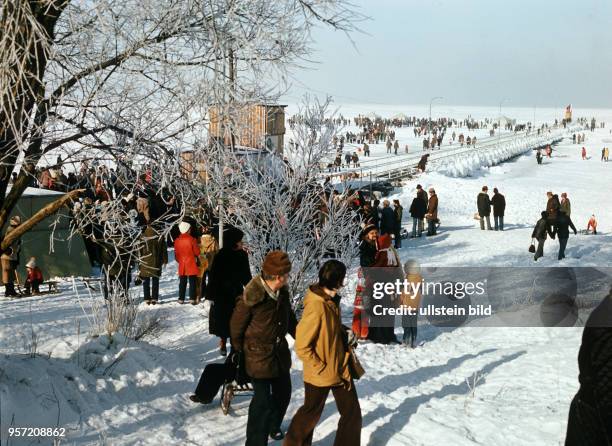 Dick angezogen laufen Spaziergänger an der zugefrorenen Ostseeküste bei Lubmin, undatiertes Foto von 1979. Hier fand am 10.und das erste...