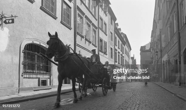 Touristen fahren mit einer Kutsche durch die Altstadt von Warschau, aufgenommen 1975.