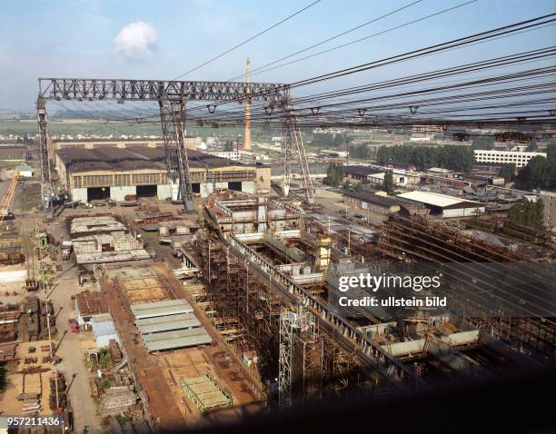 Blick auf die Warnemünder Warnowwerft mit der großen Kabelkrananlage, aufgenommen 1985. Momentan befinden sich hier zwei Schwerfrachtschiffe im Bau....