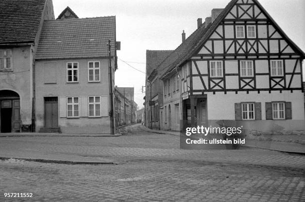 Blick in eine Straße mit grauen und tristen Häusern und einem Fachwerkhaus in der Stadt Wolgast an der Ostseeküste zur Insel Usedom, aufgenommen um...