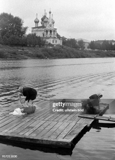 Frauen aus der Stadt Wologda waschen im Wasser eines Flusses ihre Wäsche, im HIntergrund die Sophienkathedrale am Kreml von Wologda, aufgenommen...