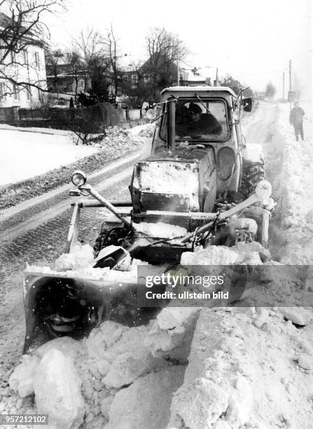 Techniker vom Winterdienst räumen am auf der Straße zwischen Hohnstein und Pirna den Schnee beiseite.