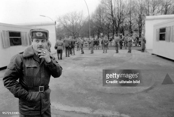 Ein DDR-Grenzsoldat gönnt sich am am Grenzübergang am Brandenburger Tor in Berlin eine Zigarette. Nach vielen anderen geöffneten Grenzübergängen...