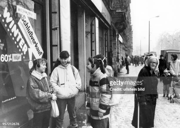 Kindr mit kopfhörern stehen von einem Geschäft in der Otto-Buchwotz-Straße in Dresden-Neustadt, aufgenommen Anfang 1990. Im Janur 1990, in der...