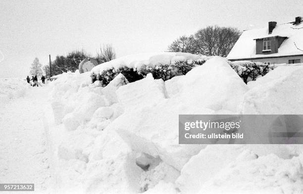 Einwohner beseitigen den vielen Schnee von ihren Häusern und der Straße, aufgenommen im Januar 1987 auf der Halbinsel Mönchgut im Südosten der...
