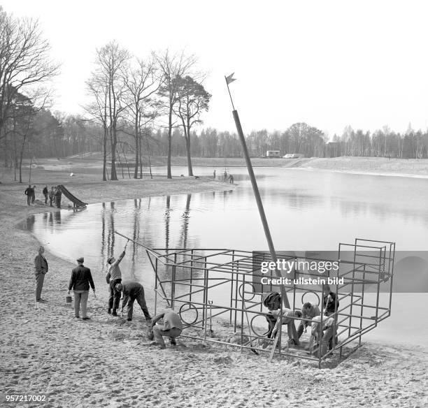 Eisenbahner vom Reichsbahnausbesserungswerk errichten für die Kinder am Strandufer des Madlower Badesees in Cottbus ein Klettergerüst in Form eines...