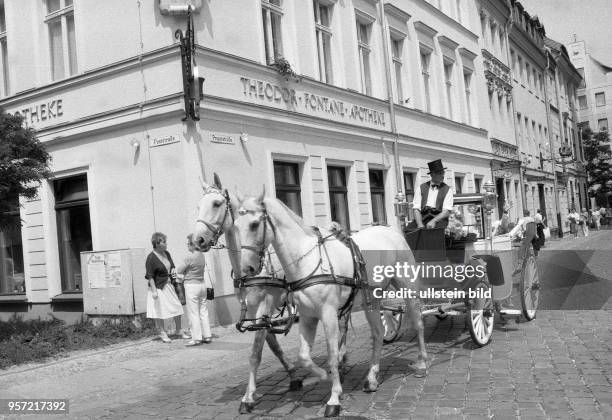 Eine Hochzeitskutsche fährt an der Ecke Post-/Propststraße vor einer historischen Apotheke durch das Nikolaiviertel in Berlin in der Wendezeit,...