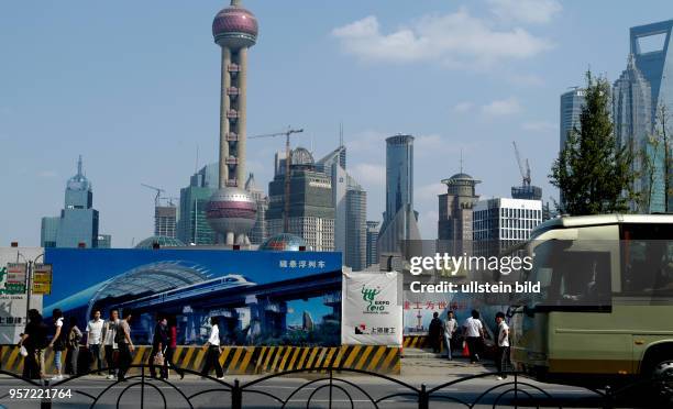 Oktober 2009 / China / Hinter einem die Sicht auf die Arbeiten an der Uferpromenade Bund verperrenden Bauzaun mit Reklame und Stadtfotos erhebt sich...