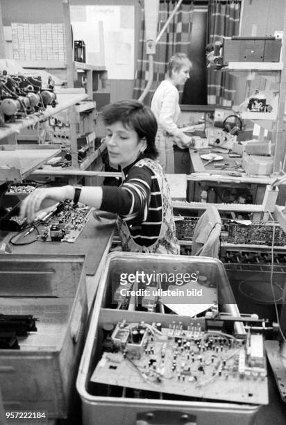 Zwei Arbeiterinnen sind im VEB Stern-Radio in Berlin-Weißensee mit der Produktion von Stereokassettenrekordern beschäftigt, aufgenommen 1990. Das...