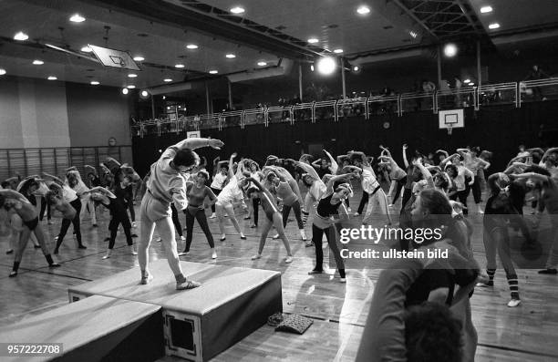 Frauen bei der Pop-Gymnastik im Sport- und Erholungszentrum an der Leninallee in Berlin, im Hintergrund beobachten Zuschauer von der Galerie aus das...