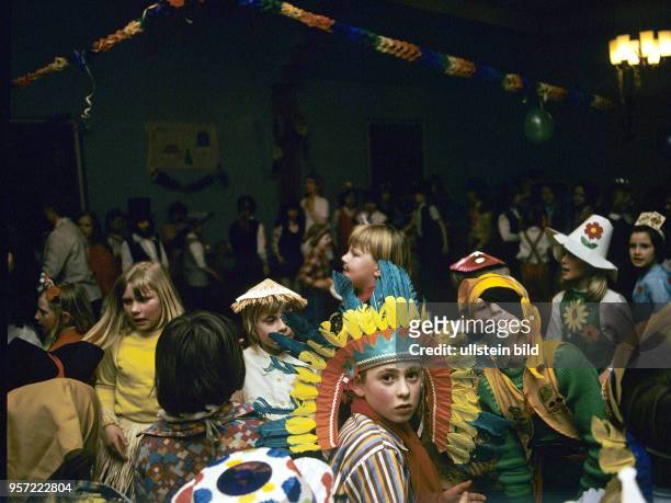 Kinder in Kostümen tanzen während einer Faschingsfeier in der Aula der Oberschule "Salvador Allende" in Putbus auf der Insel Rügen, aufgenommen 1975.