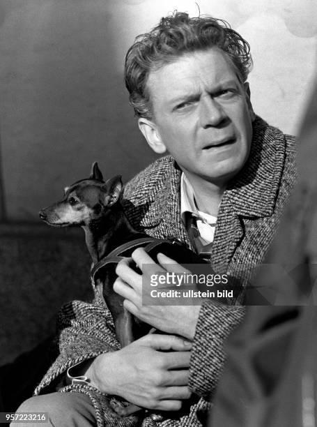 Der Komiker und Schauspieler Rolf Herricht hält während der Dreharbeiten zu dem Film "Meine Freundin Sybille" im Jahr 1967 in Dresden einen Hund auf...
