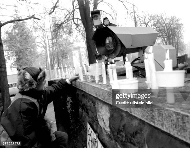 Vor einer Überwachungskamera an einer Mauer eines Gebäudes der Staatssicherheit der DDR in Dresden an der Bautzener Straße stellen Demonstranten...
