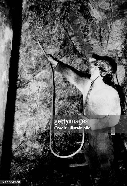 An archive photo dated 1985 shows a man checking the rocks of a shaft in the Wismut uranium mine with a Geiger counter near Aue, Germany. It has now...