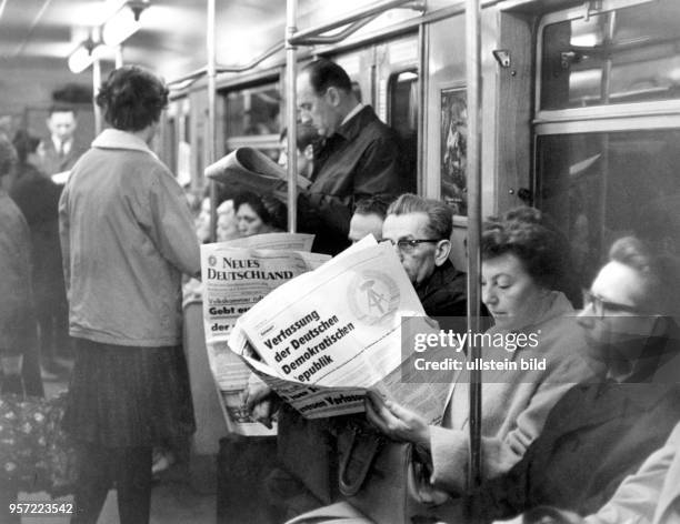 Fahrgäste lesen während ihrer Fahrt mit der U-Bahn am in Ost-Berlin die Parteizeitung der SED, "Neues Deutschland" .