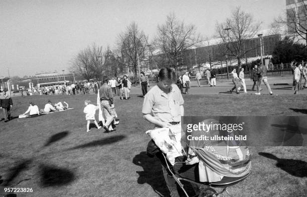 Anhänger haben am Tag der Volkskammerwahl auf dem Rasen vor dem ehemaligen ZK - Gebäude ihren Kinderwagen mit einer DDR-Fahne umspannt - im...