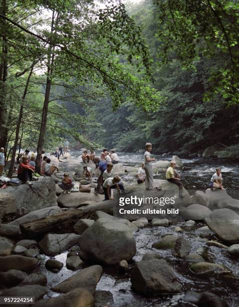 Kinder klettern über Steine am Flussbett der Bode, aufgenommen 1985 bei Thale . Die Bode entspringt im Hochharz und mündet nach 169 km bei Nienburg...