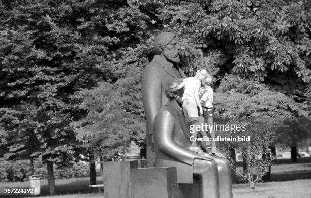 Kinder klettern auf dem Marx-Engels-Denkmal in Ostberlin nahe dem Palast der Republik, aufgenommen 1990.