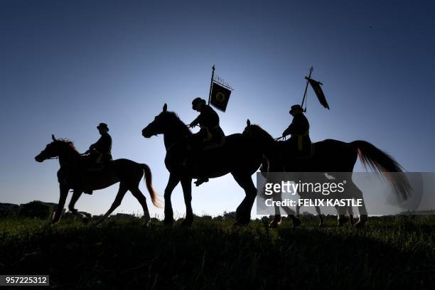 Picture taken on May 11, 2018 in Weingarten, southern Germany, shows the silhouettes of horse riders during the traditional Holy Blood Procession. -...