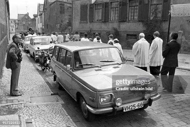 Fronleichnamsprozession in der Gemeinde Helbra an der Kupferrohhütte im Mansfelder Land, aufgenommen am . Hier wird ein am Straßenrand parkender Pkw...