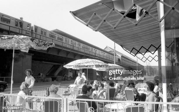 Menschen sitzen bei sommerlichen Temperaturen in einem Cafe an der Schönhauser Allee in Ostberlin beisammen, aufgenommen um 1980. Der Lärm der...