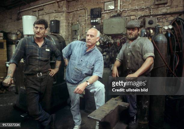 Drei Männer in einer alten dreckigen Hinterhof-Werkstatt eines kleinen Metall-Betriebes in der Brunnenstraße in Berlin-Ost, undatiertes Foto von...