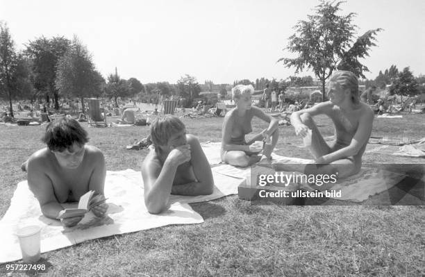 Eine Gruppe Jugendlicher auf einer Liegewiese im Freibad Pankow, undatiertes Foto vom Sommer 1989. Auch in den öffentlichen Freibädern wurde in...