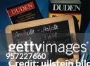 Symbolfoto zum Thema Rechtschreibreform zwei Duden hinter einer Schiefertafel mit neuen Schreibweisen verschiedener Worte: z.B. Asphalt - Asfalt;...