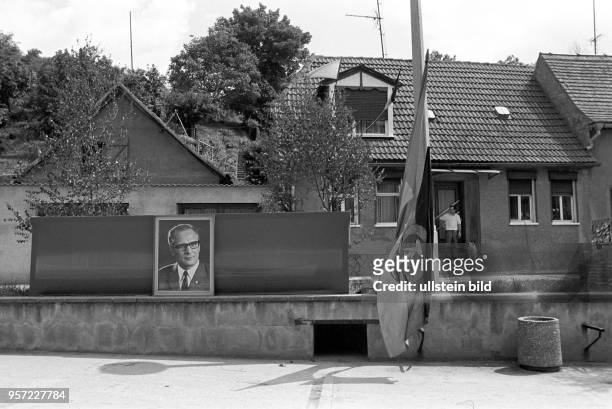 Noch künden nur eine DDR-Fahne und ein Porträt-Foto von DDR-Staats- und -Parteichef Erich Honecker am Straßenrand von dem bald steigenden...