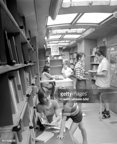 Kinder und Erwachsene beim Aussuchen von Büchern in der Fahrbücherei der Stadt-und Bezirksbibliothek Dresden im Juli 1976 in Dresden. 7.500 ständige...