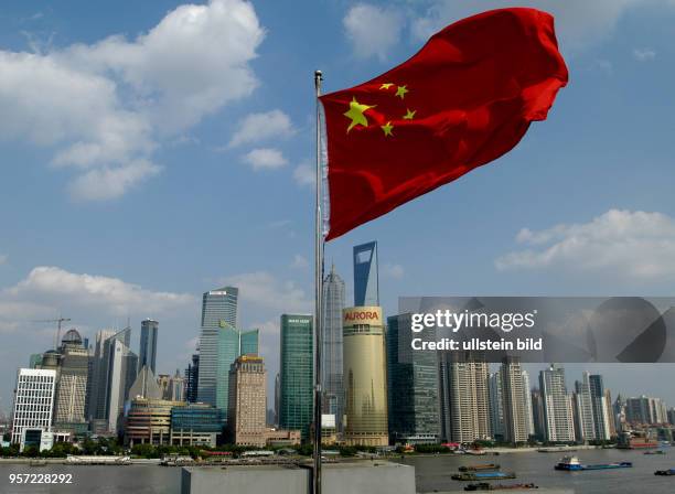 Oktober 2009 / China / Die Fahne der Volksrepublik China weht im Vordergrund vor dem Fluss Huangpu und der Skyline von Pudong mit den höchsten Bauten...