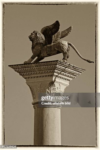 Szene aus Venedig - der geflügelte Markuslöwe auf einer der beiden Säulen auf der Piazzetta am Markusplatz in Venedig - mittels eines...