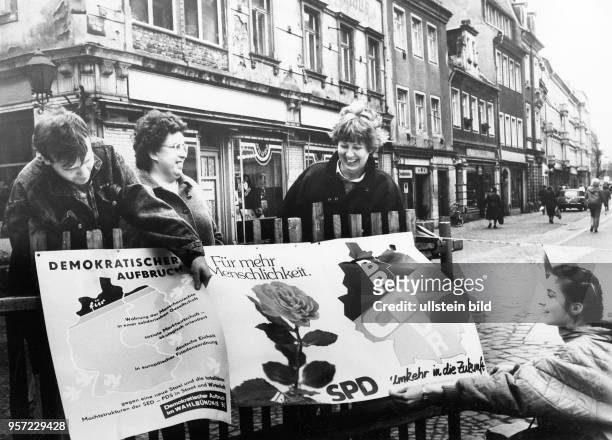 Die ersten freien Wahlen werden in der DDR vorbereitet, Wahlhelfer kleben Wahlplakate der verschieden, auch neuen Parteien in einer Hauptstraße in...