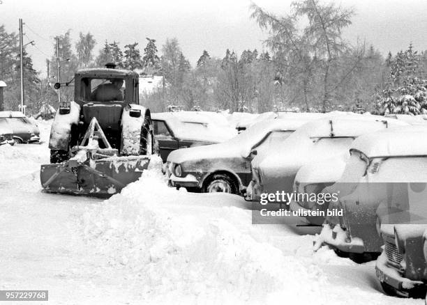 Ein LPG-Traktorist mit Schneepflug räumt im Januar 1987 mit seinem Fahrzeug einen Parkplatz in Schellerhau im Osterzgebirge.
