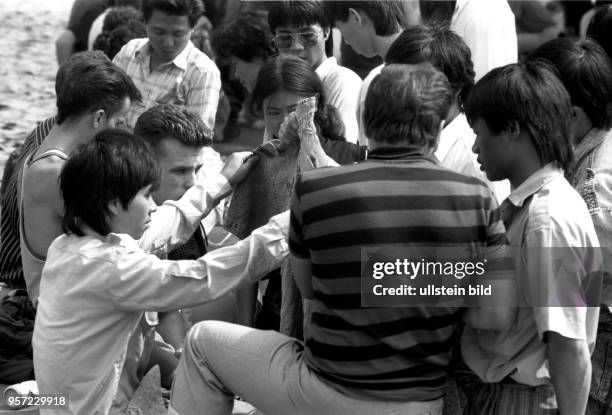 Im August 1990 blüht in der Prager Straße in Dresden der Schwarzhandel, hier kaufen Vietnamesen Jeanskleidung von Osteuropäern. Mit der Öffnung der...