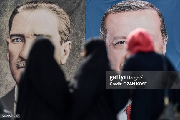 Women stand in front of the portraits of Turkish President Recep Tayyip Erdogan and founder of modern Turkey Mustafa Kemal Ataturk , on May 11, 2018...