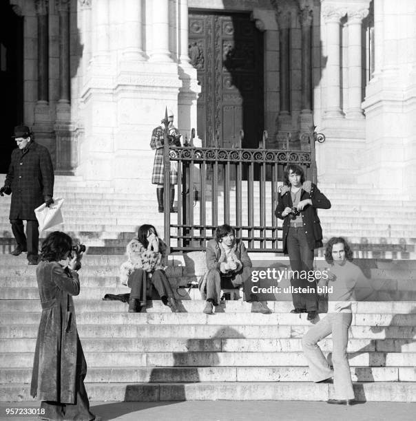 Touristen fotografieren sich auf der Treppe der Basilika Sacre Coeur de Montmartre, aufgenommen im November 1970 in Paris. Die Basilika ist eine der...