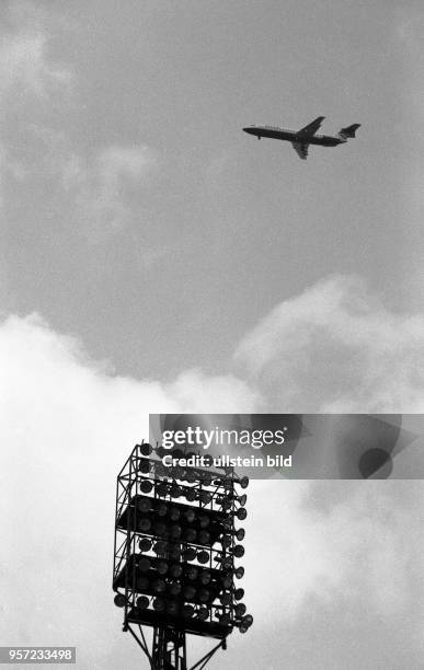 Ein Flugzeug, gestartet vom Flughafen Tegel in Berlin-West befindet sich am Himmel über dem Stadtteil Wedding in Westberlin - vorn im Bild ein...