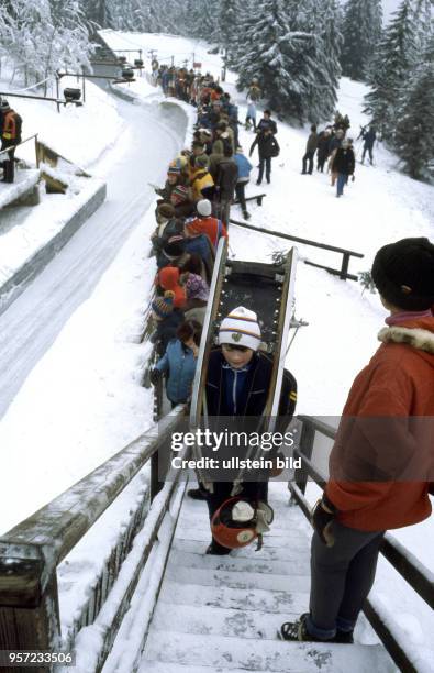 Zur VII. Kinder- und Jugendspartakiade im Februar 1979 betritt ein junger Rodler mit seinem Schlitten auf dem Rücken die Treppe zur Abfahrt auf der...