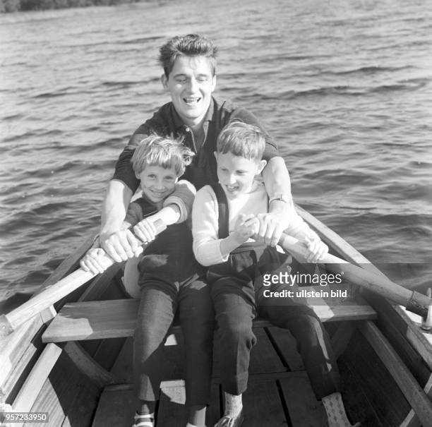 Ein Mann mit einem Mädchen und einem Jungen beim Rudern mit einem Boot auf einem Berliner Gewässer, undatiertes Foto aus den frühen 1960er Jahren.