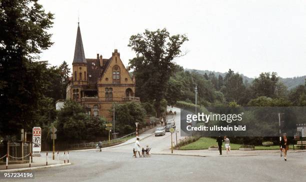 Blick über eine Straßenkreuzung in Eisenach zur heutigen Wartburgallee, der Zufahrt zur Wartburg, aufgenommen 1969. Am Straßenrand prangt ein...