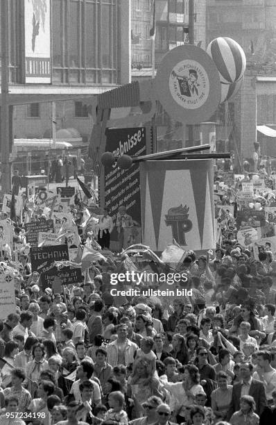 Junge Pioniere stellen auf der Demonstration am 1. Mai 1988 in der Karl_Marx_Allee in Berlin Wagen mit überdimensionaler Fanfare und Trommel und der...