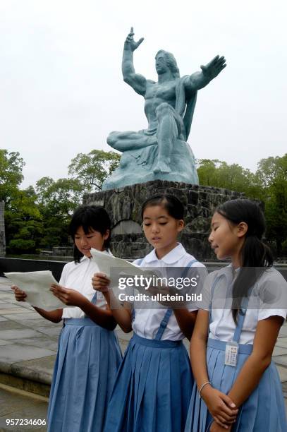 Japan / Nagasaki /Japanische Schüler im Friedenspark vor der 10 Meter hohe Friedensstatue von Kitamura Seibo in der Atombomben-Gedenkstätte von...