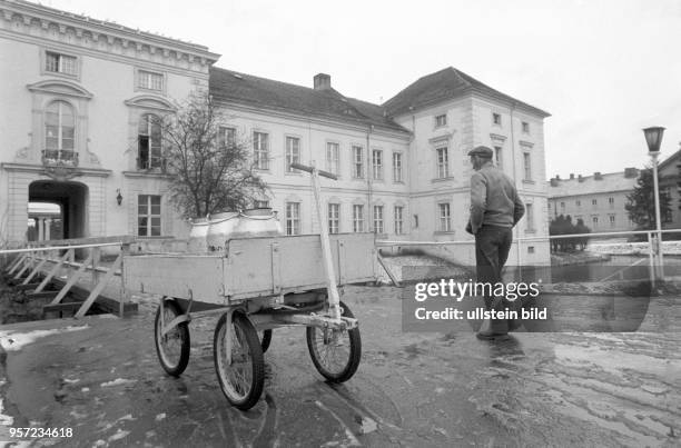 Ein Handkarren mit Milchkannen steht vor dem historische Gebäude Schloss Rheinsberg in Rheiunsberg, Foto vom . Im Schloss ist seit 1953 das...